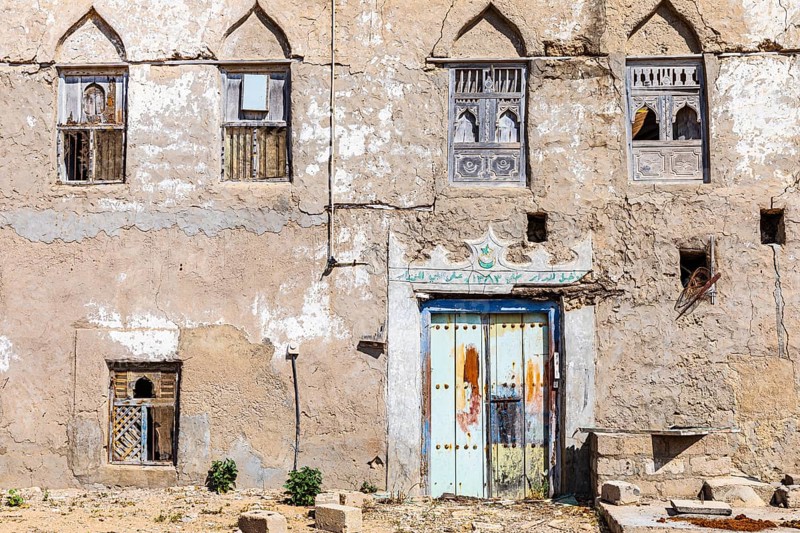 Old, weathered shutters and front door in the deserted neighbourhood of Mirbat, Dhofar Province, Arabian Peninsula, Sultanate of Oman