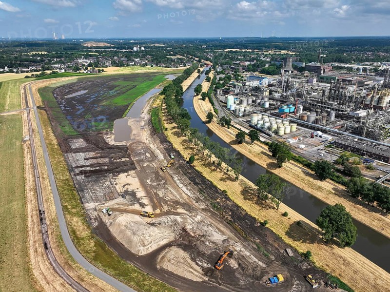 Oberhausen, North Rhine-Westphalia, Germany, renaturalisation of the Emscher in the Holtener Bruch. OQ Chemicals plant Ruhrchemie on the right. The currently straightened Emscher, shown here at flood level, has been given curves again and can meander through its new floodplain. The ecological conversion of the Emscher system consists of the construction of a centralised wastewater treatment system in the Ruhr region, the construction of sewers and the renaturation of the Emscher and its tributaries. Following the construction of a parallel sewer, the Emscher has been completely free of sewage since January 2022. The river was previously an open, above-ground combined sewer with rainwater and wastewater, Europe