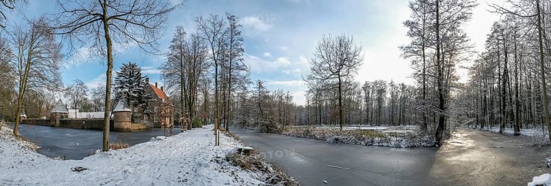 Wide winter landscape near moated castle Haus Welbergen with frozen water and trees, Ochtrup-Welbergen, Münsterland, North Rhine-Westphalia, Germany, Europe