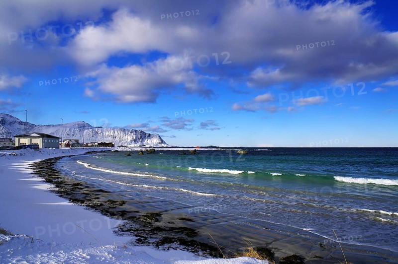 Snowy beach with gentle waves, blue sky and scattered clouds, quiet winter scenery, Ramberg, Flakstad, Lofoten, Nordland, Norway, Europe