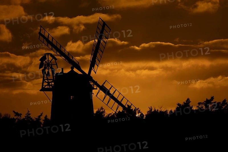 Windmill silhouette at sunset with a red sky and clouds behind, Cley-next-to-the-sea, Norfolk, England, United Kingdom, Europe