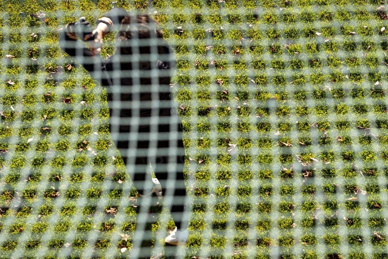 Golfer Training on Driving Range Behind a Net