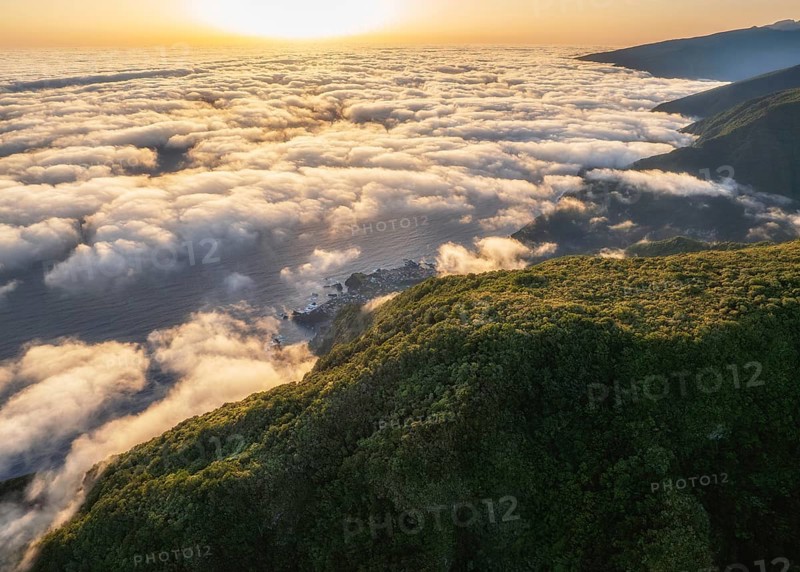 Aerial view of sunrise above clouds and green hills at Fanal mountain, Madeira island, Portugal, Europe
