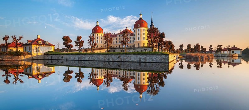 Moritzburg Castle in autumn under a blue sky, reflection in the castle pond, hunting lodge of Augustus the Strong, water reflection in the lake, morning light, Saxony, Germany, Europe
