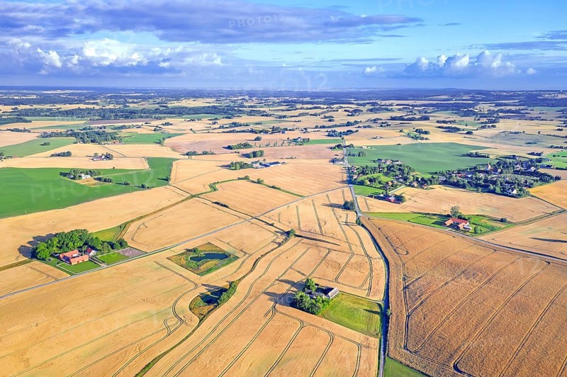 Aerial view over agricultural wheat fields, meadows, farmland and farms in Skåne län, Scania County, southernmost province of Sweden, Scandinavia