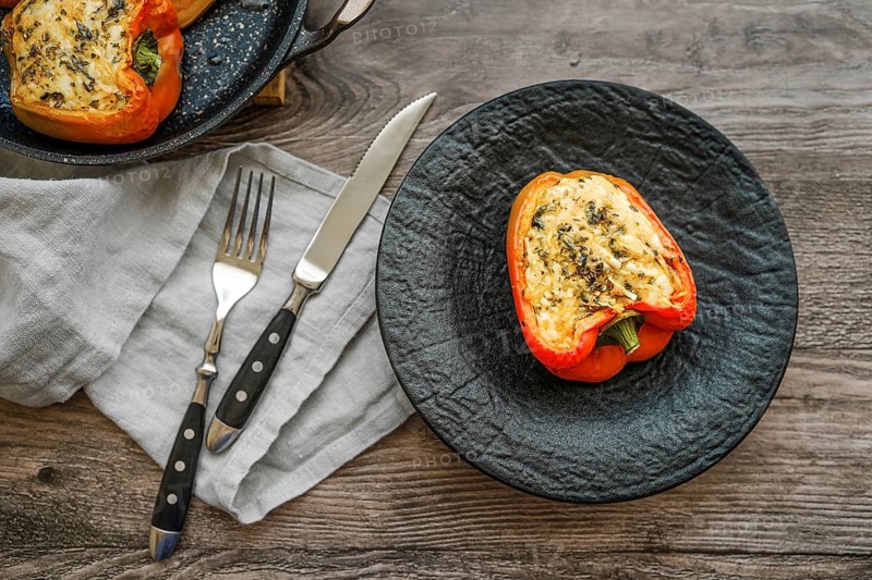 Close-up view of roasted bell peppers stuffed with goat cheese and mozzarella on wooden table
