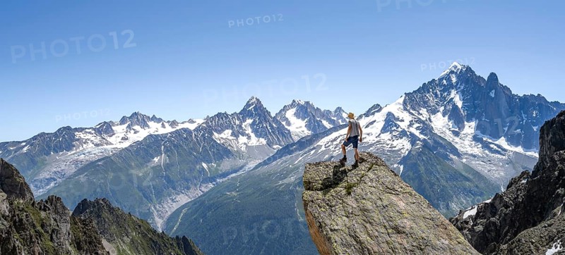 Mountaineer standing on a rock, mountain landscape with mountain peak Aiguille Verte, Mont Blanc massif, Aiguilles Rouges, Chamonix-Mont-Blanc, Haute-Savoie, France, Europe