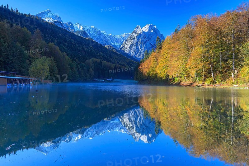 Mountains reflected in lake, fog, morning light, autumn colours, Riessersee, Waxensteine behind, Wetterstein range, Garmisch-Partenkirchen, Bavaria, Germany, Europe