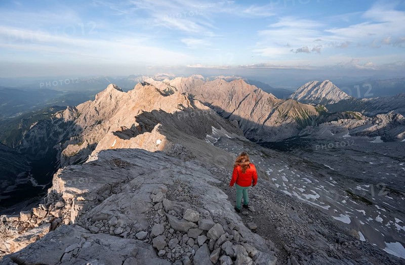 Mountaineer on a steep rocky ridge, impressive mountain landscape, view of the Höllental and the Alpspitze from the Jubiläumsgrat, in the evening light Zugspitze, Wetterstein range, Bavaria, Germany, Europe