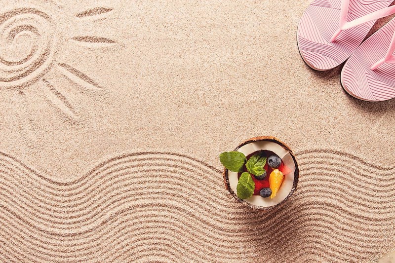 Abstract background, Summer wallpaper, drawing on sand, sea waves and sun, coconut with summer berries, flip-flops, horizontal, no people