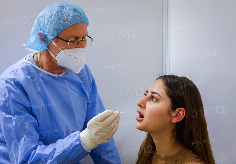 Essen, North Rhine-Westphalia, Germany - Corona test centre Grugahalle open for free citizen test, Covid rapid test, a doctor tests a young woman for the coronavirus using a throat swab, from 8 March, German citizens can be tested for corona once a week free of charge at the rapid test centre