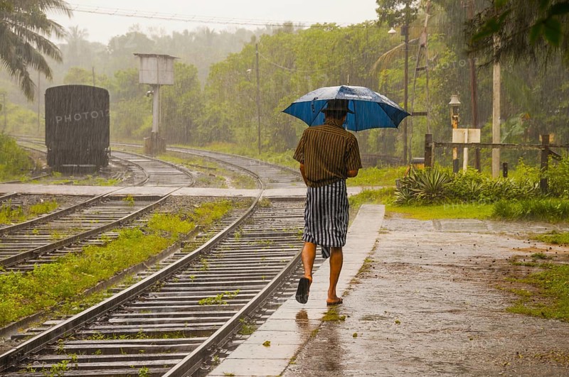 Sinhalese with umbrella in heavy rain, monsoon, railway station in Kalawewa, Sri Lanka, Ceylon, South Asia Asia, Asia