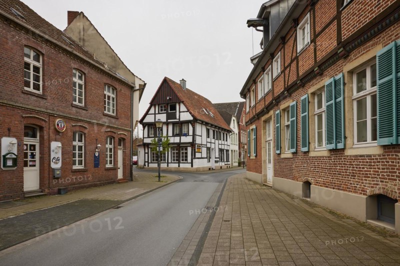 Historic brick houses with white windows and shutters and a small half-timbered house in Warendorf, Warendorf district, North Rhine-Westphalia, Germany, Europe