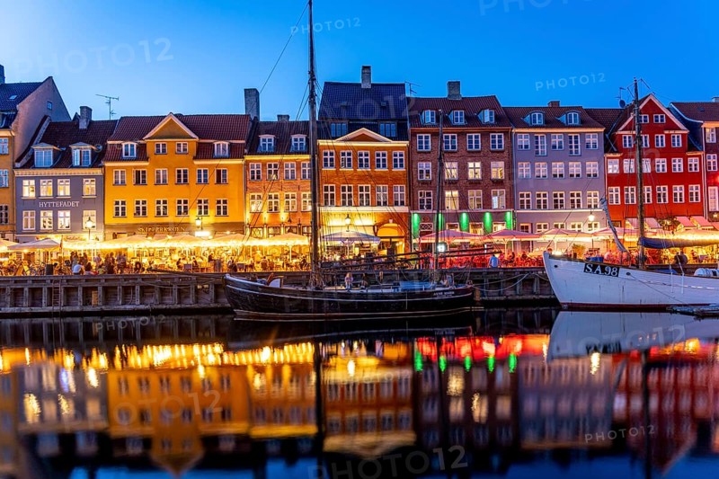 Colourful houses, restaurants and historic ships on the Nyhavn canal and harbour at dusk, Copenhagen, Denmark, Europe