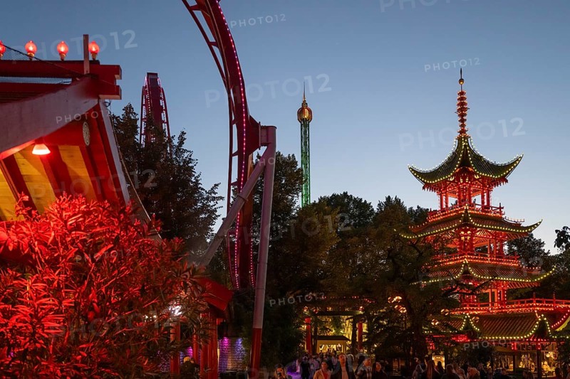 Red and yellow illuminated pagoda, roller coaster, Tivoli Amusement and Recreation Park, Copenhagen, Denmark, Europe