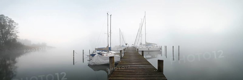 Quiet autumn morning on Lake Chiemsee, jetty with sailing boats in dense fog, Prien am Chiemsee, Bavaria, Germany, Europe