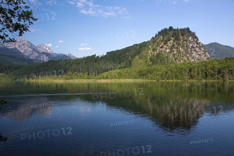 Lake Almsee in summer with totally smooth surface showing reflexion of the mountain Ameisstein