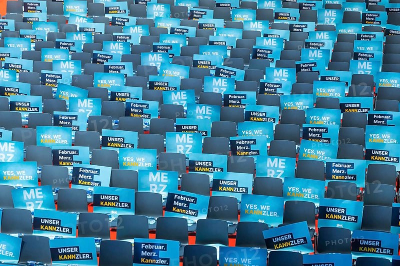 Assembly hall, deserted with many empty chairs and posters with the inscription UNSER KANNZLER. Bundestag election campaign of the CDU party for the party's candidate for chancellor Friedrich Merz, symbolic photo. Election rally in Künzelsau, Baden-Württemberg, Germany, Europe