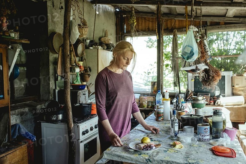 Olena in the house of the Cossack Oleksandr. She comes from Donetsk, her man is friends with Oleksandr, he himself is fighting in the army at the front in Donbass. Olena and her son are staying with Oleksandr during the war, Trakhtimirov, Romashki Island, Ukraine, 2022, Europe
