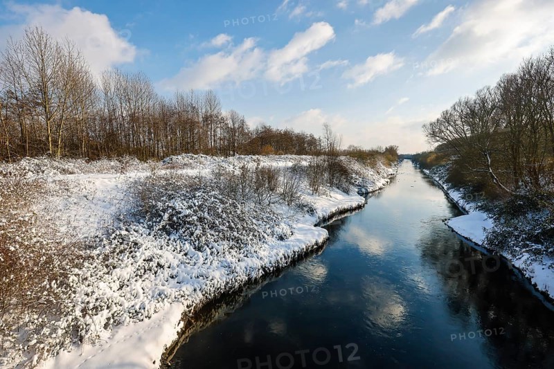Dortmund, North Rhine-Westphalia, Germany - Sunny winter landscape in the Ruhr area, ice and snow on the renaturalised Emscher, the ecological conversion of the Emscher system consists of the construction of a central wastewater treatment system in the Ruhr area, the construction of underground sewers and the renaturalisation of the Emscher and its tributaries