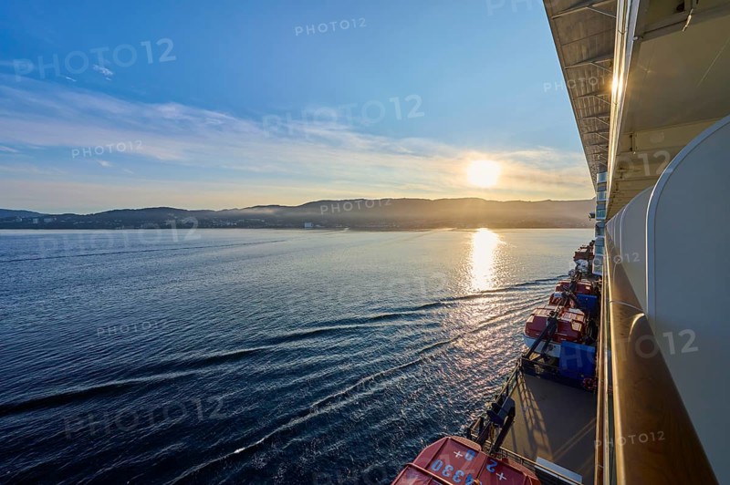 View from a cruise ship, Mein Schiff 6, of the calm sea at sunrise with soft clouds in the sky, Bergen, Vestland, Norway, Europe