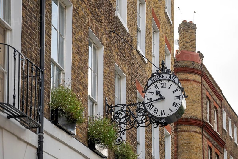 Classic clock with original lettering You're late on a building facade, Doughty Street, Holborn, London Borough of Camden, England, United Kingdom, Europe