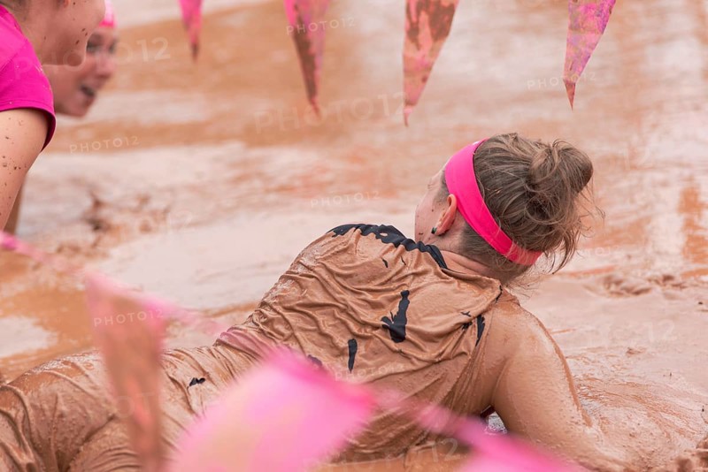 Group of participants in a muddy outdoor obstacle course