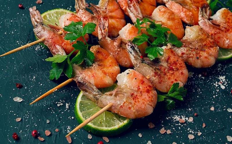 Shrimp kebab, with spices, lime, on wooden skewers, top view, no people