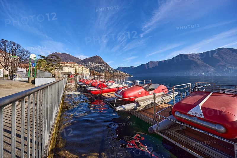 Pedal boats, metal railing, lake, shore, pavement, pedal boat rental, mountain landscape, haze, blue sky, cirrus clouds, veil clouds, Lake Lugano, street Riva Giocondo Albertolli, Lugano, district Lugano, canton Ticino, Switzerland, Europe