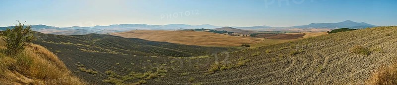Typical Tuscan landscape in Val d'Orcia with hills, trees, fields, farmhouses and cypresses in summer, Tuscany, Italy, Europe