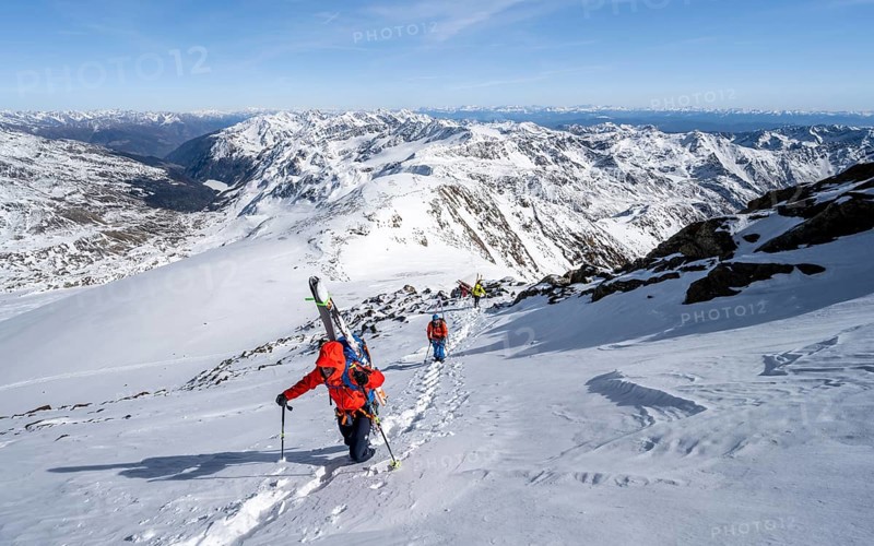 Ski tourer on foot, carrying skis on backpack, mountain panorama, snow-covered mountain landscape in winter, high tour, ascent to Monte Cevedale, Ortler Alps, Vinschgau Valley, Italy, Europe