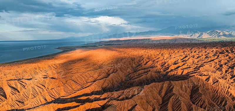 Landscape of eroded hills, badlands at sunset, Issyk Kul Lake in the background, aerial view, Canyon of the Forgotten Rivers, Issyk Kul, Kyrgyzstan, Asia