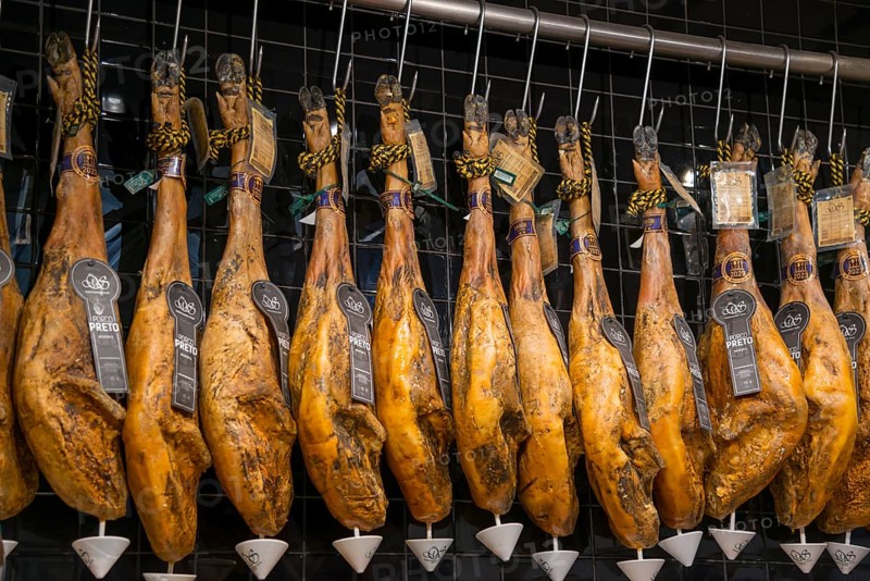 Reihe von traditionell aufgehängten Schinken in einem Delikatessengeschäft, Mercado da Ribeira, Lissabon, Lisboa, Portugal, Europe