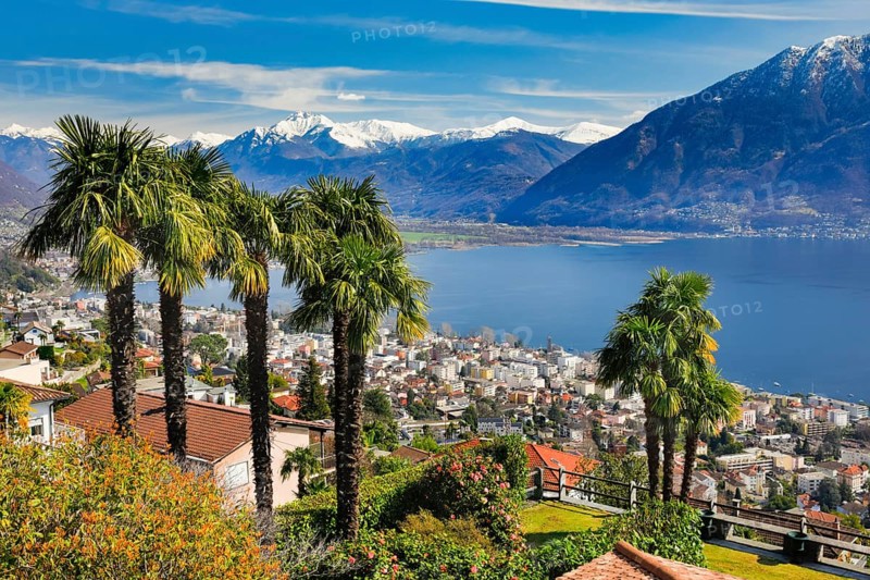 View over the city of Locarno and Lake Maggiore with snow-capped mountains in the background, Canton Ticino, Switzerland, Europe