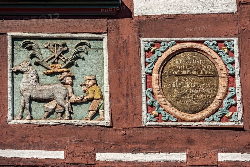 Colourful painted carvings, relief for blacksmith Johenrich Jung, medallion with inscription, on the half-timbered house Gasthaus Zum Goldenen Löwen, market square, historic old town, Butzbach, Wetterau, Hesse, Germany, Europe
