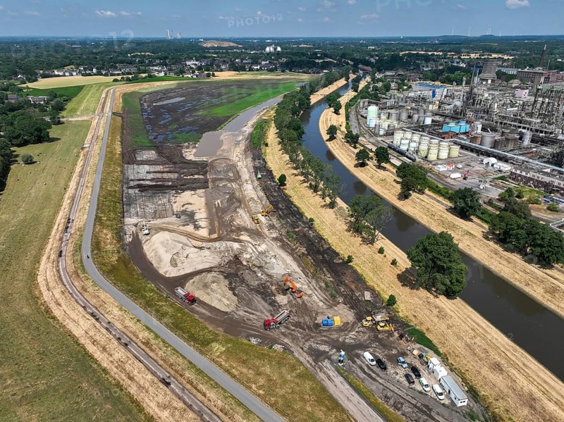 Oberhausen, North Rhine-Westphalia, Germany, renaturalisation of the Emscher in the Holtener Bruch. OQ Chemicals plant Ruhrchemie on the right. The currently straightened Emscher, shown here at flood level, has been given curves again and can meander through its new floodplain. The ecological conversion of the Emscher system consists of the construction of a centralised wastewater treatment system in the Ruhr region, the construction of sewers and the renaturation of the Emscher and its tributaries. Following the construction of a parallel sewer, the Emscher has been completely free of sewage since January 2022. The river was previously an open, above-ground combined sewer with rainwater and wastewater, Europe