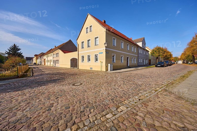 Residential building, cobblestone pavement, blue sky with cirrostratus clouds, intersection of Altstädter Graben and Lindenstraße, Mühlberg Elbe, Elbe-Elster district, Brandenburg, Germany, Europe