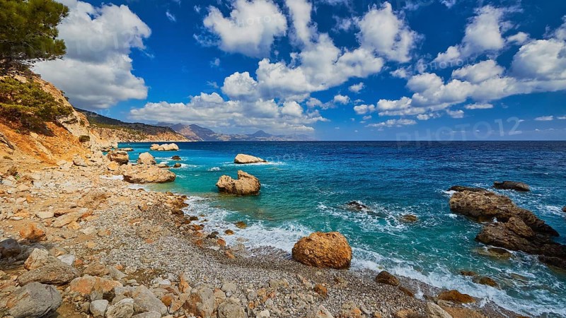 Quiet beach with large rocks framed by deep blue water and a wide sky, Kato Lakkos Beach, still almost unspoilt bay, not accessible by car, Kato Lakkos, East Coast, Karpathos, Dodecanese, Greek Islands, Greece, Europe