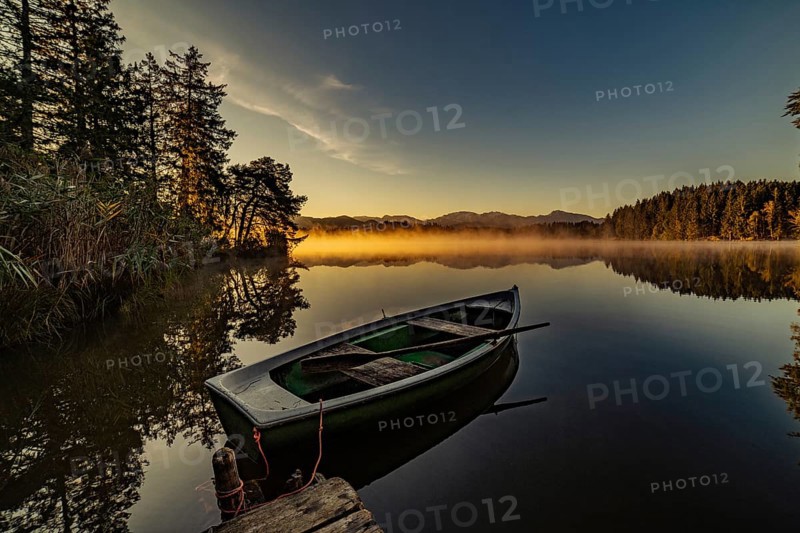 Boats in the autumnal Schmutter Weiher in the Allgäu near the municipalities of Halblech, Roßhaupten and Lechbruck in Ostallgäu in the foothills of the Alps