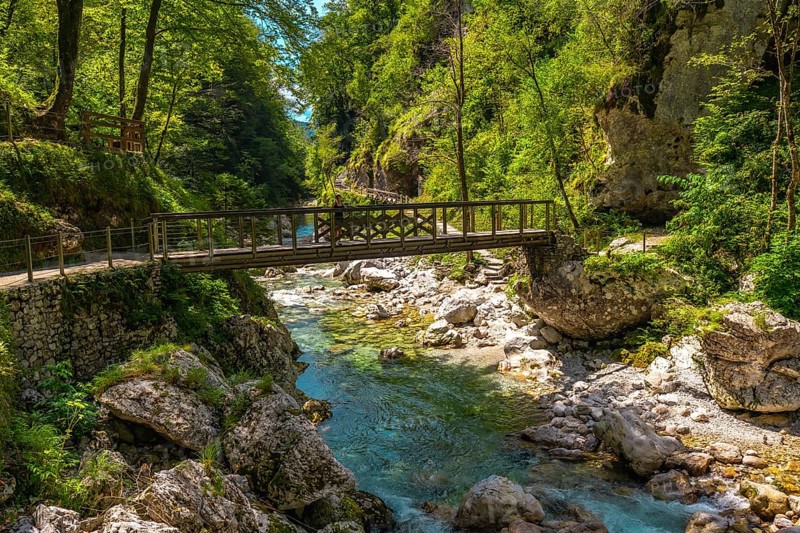 Turquoise water flowing under wooden bridge over tolmin gorges in triglav national park, slovenia
