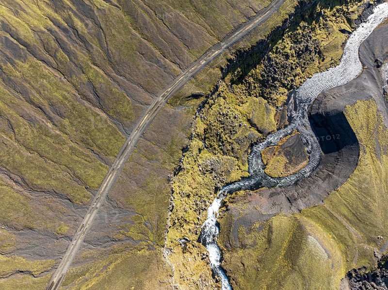 River along road F232 Öldufellsleid, slopes of Mt. Öldufell, moss-covered hill in black lava sand, aerial view, Iceland, Europe