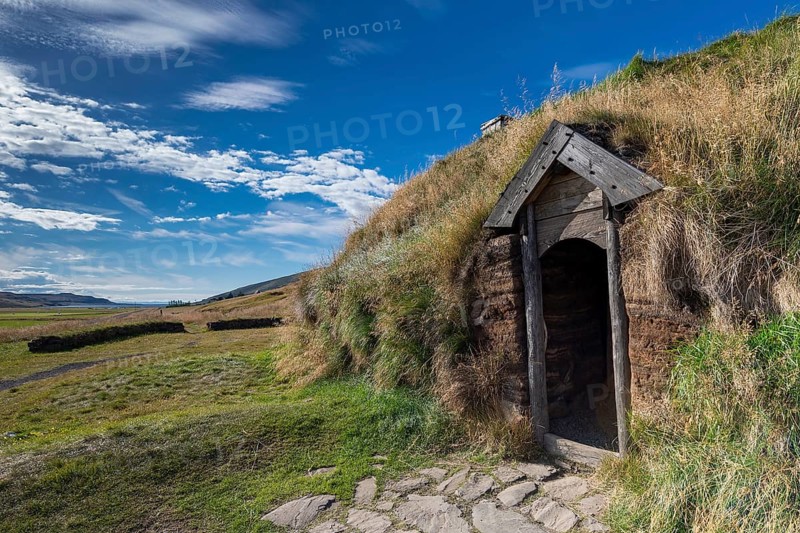 Traditional turf house with wooden door and grass roof in the sunshine, replica of a Viking longhouse, home of Eiríkr Þorvaldsson or Erik the Red, Eiríksstaðir, Iceland, Europe