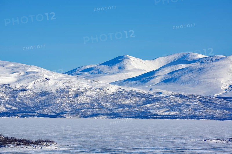 Snow-capped mountains and a frozen lake under a clear blue sky, Abisko, Abisko National Park, Torneträsk, Lapland, Sweden, Europe