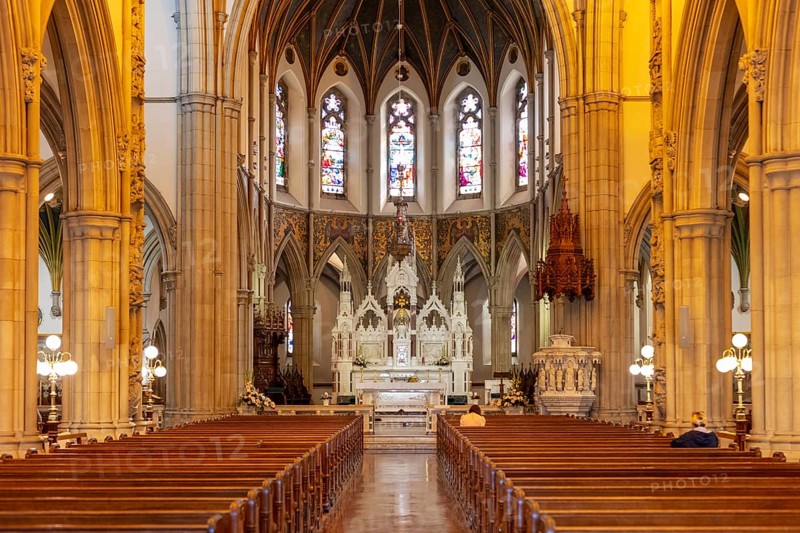 Magnificent interior of a church with a view of the altar and ornate Gothic arches under a warm light, Letterkenny