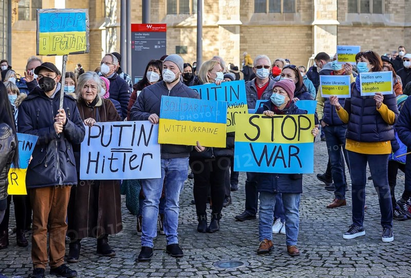 Wesel, North Rhine-Westphalia, Germany, Demonstration against Putin's war in Ukraine. Peace demonstration and solidarity rally for Ukraine on the large market square in Wesel. An old woman holds a banner PUTIN = HITLER. In times of the corona pandemic, all demonstrators wear masks, Europe