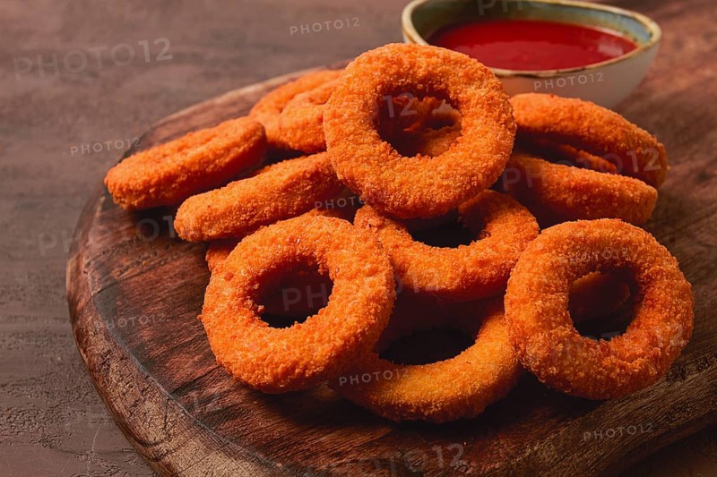 Crispy chicken rings, fried, on a wooden board, close-up