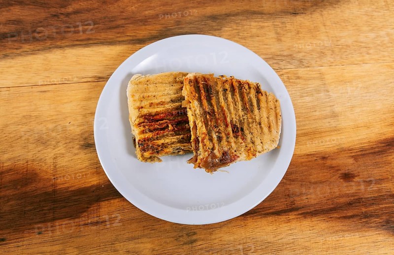 Top view of two meat and chicken panini on wooden table