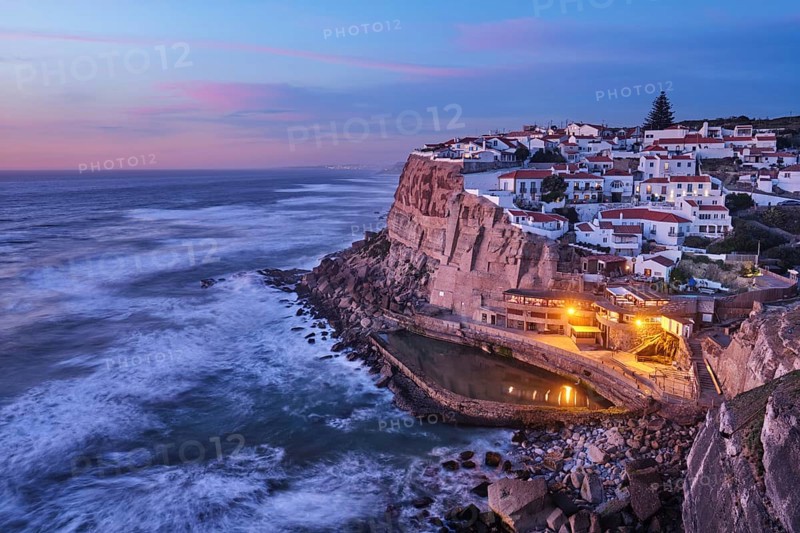 Scenic view of the seaside Azenhas do Mar fishing village on cliff on Atlantic ocean coast, Portugal in evening twilight dusk
