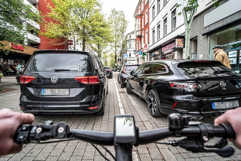 Cycling in the city, inner-city street, cycle lane, bicycles have priority, two-lane traffic with parked cars on both sides, cyclists' perspective, Essen, North Rhine-Westphalia, Germany, Europe