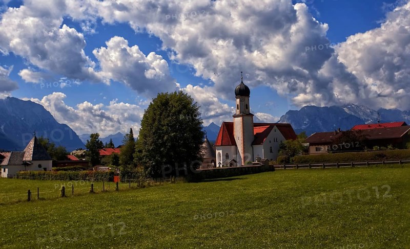 Idyllic village with church and mountains in the background under a blue sky, Wallgau, Bavaria, Germany, Europe